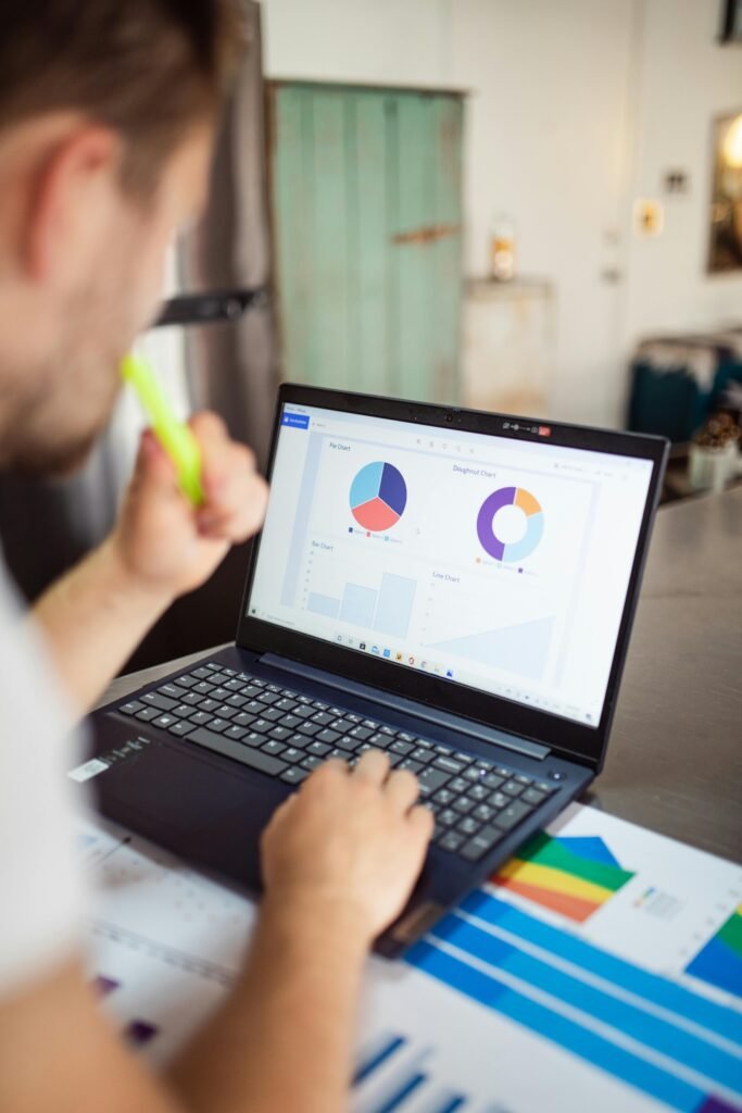 pexels photo 7947656 7947656 Focused adult analyzing charts and graphs on a laptop for business insights.