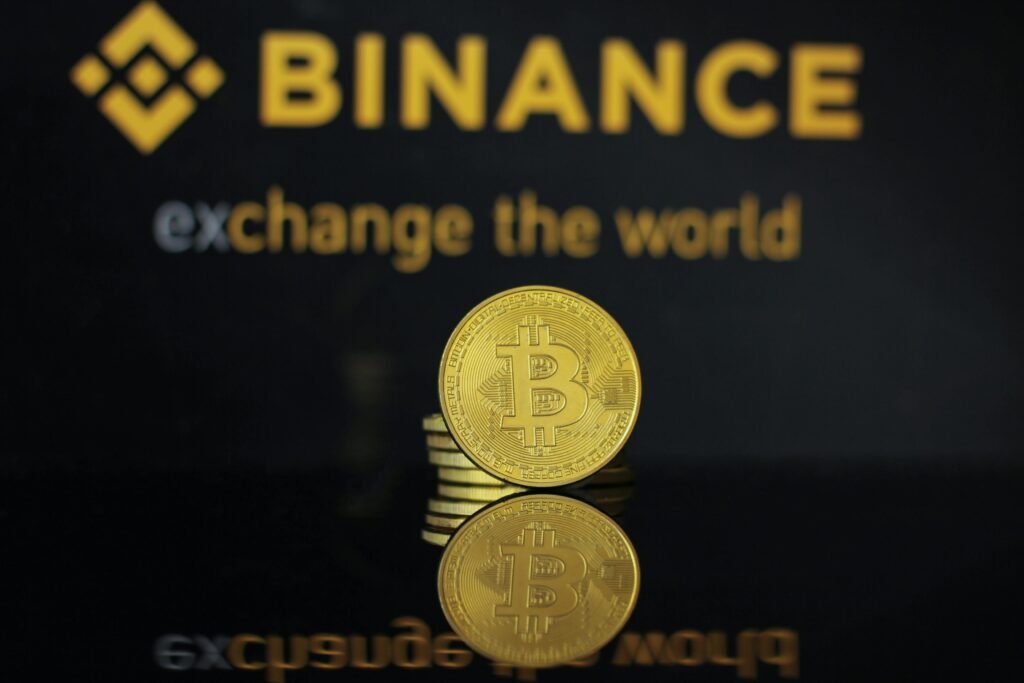 pexels photo 9169177 9169177 Close-up of a Bitcoin coin with Binance logo and text reflecting in dark surface.